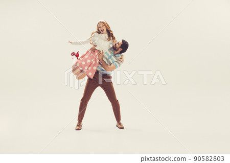Young man and woman in vintage retro style outfits dancing social dance isolated on white background. Timeless traditions, 1960s american fashion style and art. 90582803
