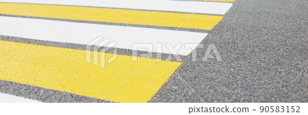 Marked white and yellow walkway across road or street 90583152