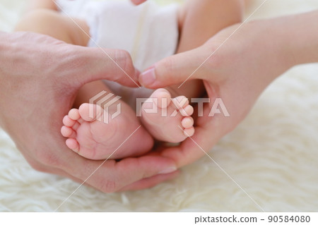 Heart with newborn feet and dad and mom's hands 90584080