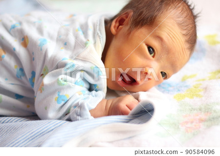 1個月大的嬰兒試圖抬起他的臉在他的肚子上 1個月大的嬰兒試圖抬起他的臉在他的肚子上 90584096