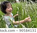 Beautiful little cute girl is picking up flower in the grass field with copy space 90584131