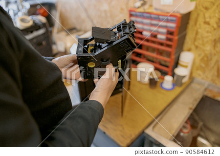 Professional worker inspecting detail of coffee machine in workshop Professional worker inspecting detail of coffee machine in workshop 90584612