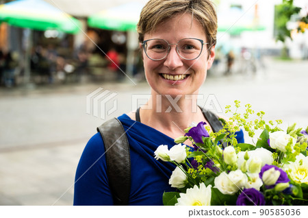 Attractive 35 year old white woman holding a flower bouquet Attractive 35 year old white woman holding a flower bouquet 90585036