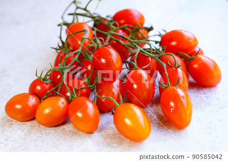 Close-up of mini tomatoes with tufts, white background Close-up of mini tomatoes with tufts, white background 90585042