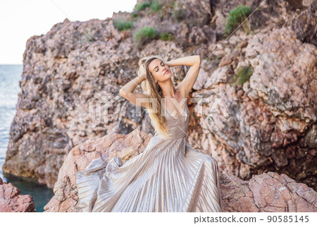 Woman tourist against the backdrop of rocks in Montenegro. Panoramic summer landscape of the beautiful green Royal park Milocer on the shore of the the Adriatic Sea, Montenegro 90585145