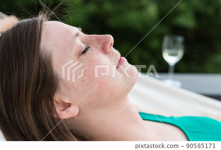 Laeken, Brussels Capital Region - Belgium - Portrait of a young white attractive thirty year old woman lying eyes closed in a hammock Laeken, Brussels Capital Region - Belgium - Portrait of a young white attractive thirty year old woman lying eyes closed in a hammock 90585171