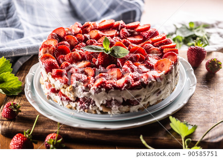 Strawberry cream cake with sponge cakes on a white plate Strawberry cream cake with sponge cakes on a white plate 90585751