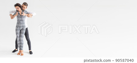 Banner couple dancing latin dance bachata, merengue, salsa, kizomba. Two elegance pose over white background with copy space Banner couple dancing latin dance bachata, merengue, salsa, kizomba. Two elegance pose over white background with copy space 90587040