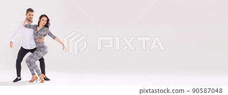 Banner social dance bachata kizomba zouk tango concept - Man hugs woman while dancing over white background with copy space Banner social dance bachata kizomba zouk tango concept - Man hugs woman while dancing over white background with copy space 90587048