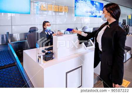 Passenger giving his documents for check-in to airport manager by counter Passenger giving his documents for check-in to airport manager by counter 90587222