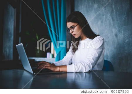 Serious woman working and surfing laptop 90587393