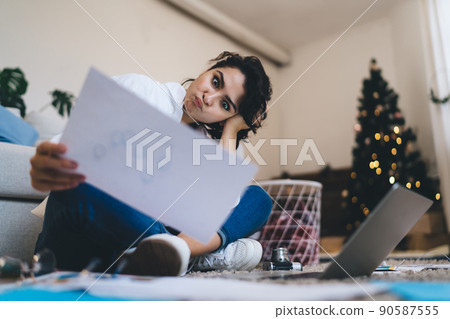Funny woman with grimace reading document during online work 90587555