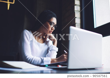 Serious woman working with documents and laptop 90587561