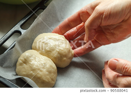 Confectioner forms buns with cherries from baking dough 90588041