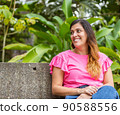 latina woman sitting in a bench in the park 90588556