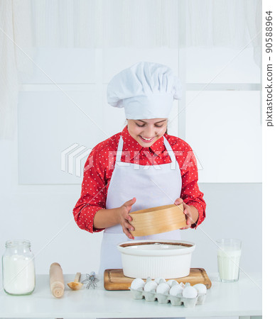 Look whats cooking. happy teen girl cooking dough. kid in chef uniform. culinary and cuisine. 90588964