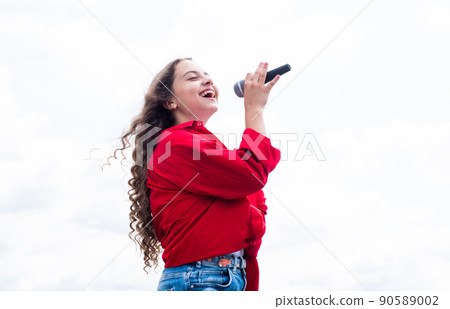 teen girl singing song in microphone on sky background, music teen girl singing song in microphone on sky background, music 90589002