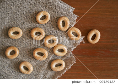 Round drying bags scattered on a linen napkin, on an old wooden table. Space for copying. Top view. High quality photo 90589382