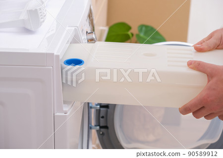 A man takes out container from the dryer to A man takes out container from the dryer to 90589912