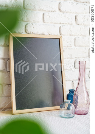 Desk with photo frame and minimal vases against white wall Desk with photo frame and minimal vases against white wall 90590072