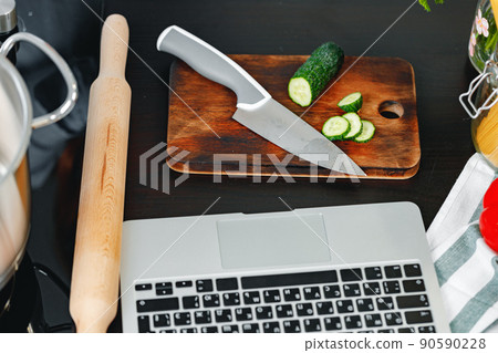 Top view of kitchen table with laptop and cutting board 90590228