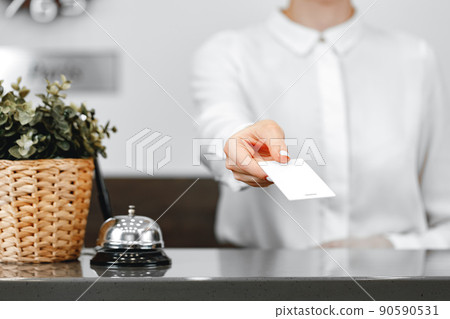 Close up of woman hotel receptionist giving you door key Close up of woman hotel receptionist giving you door key 90590531