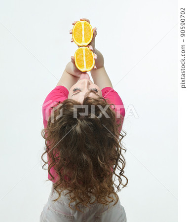 attractive girl with oranges in her hands photo shoot in the studio on a white background attractive girl with oranges in her hands photo shoot in the studio on a white background 90590702