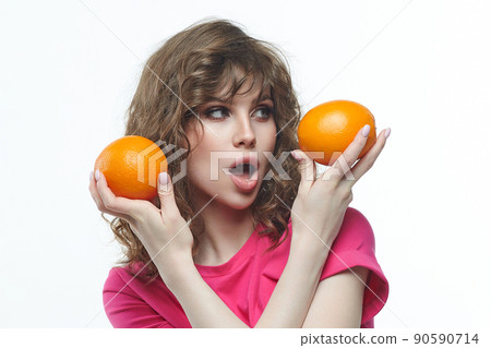 attractive girl with oranges in her hands photo shoot in the studio on a white background attractive girl with oranges in her hands photo shoot in the studio on a white background 90590714