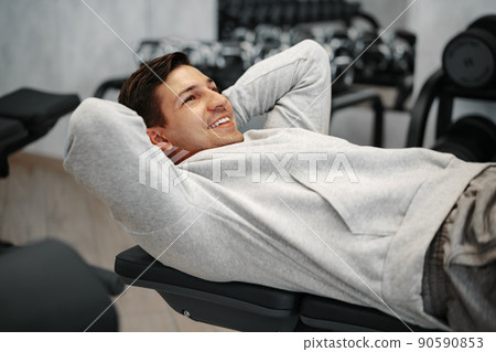 Young athlete doing abs exercises workout in modern gym 90590853