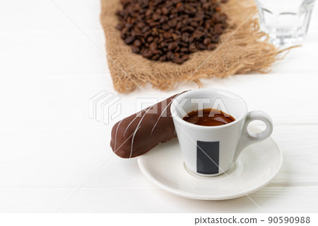 Cup of coffee and saucer with chocolate sweets on wooden table 90590988
