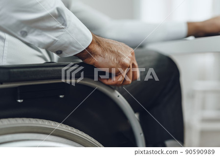 Unrecognizable man sitting in wheelchair close up 90590989