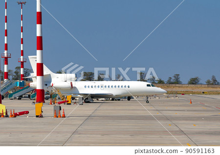 Airplane is parked near gate of airport terminal 90591163