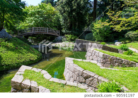 Winding stone banks near the stream and walking through it in a Japanese park 90591197