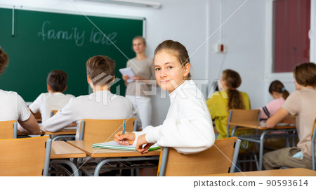 Teenage schoolgirl in classroom during lesson Teenage schoolgirl in classroom during lesson 90593614
