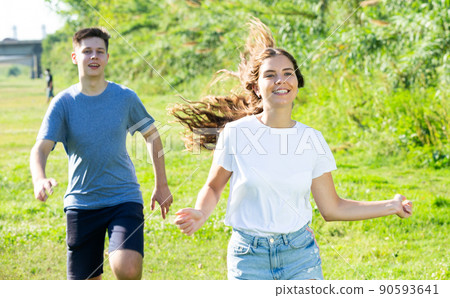 Cheerful teenagers are jogging together in park and having fun Cheerful teenagers are jogging together in park and having fun 90593641