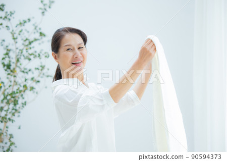 Senior women hanging out the laundry 90594373