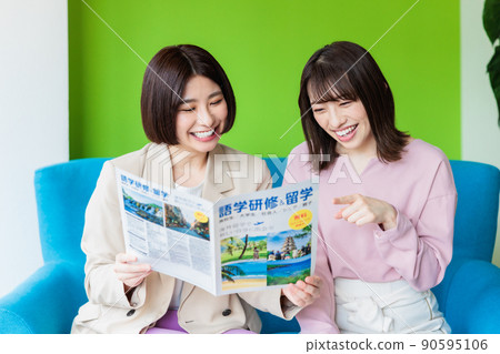 A woman looking at a language study abroad pamphlet at a cafe 90595106