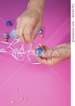 The female hands of the master assemble a handmade product from felted wool The female hands of the master assemble a handmade product from felted wool 90595761