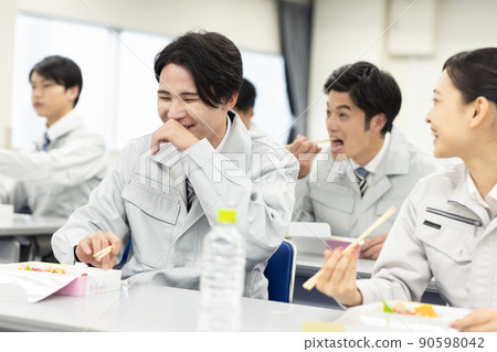 穿著工作服的男女在會議室吃午飯 90598042