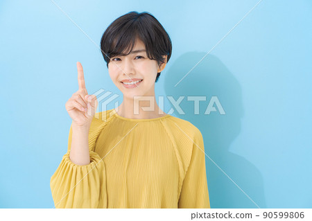 Female portrait in her 20s, light blue background Female portrait in her 20s, light blue background 90599806