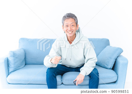 An elderly man watching sports on his home TV 90599851