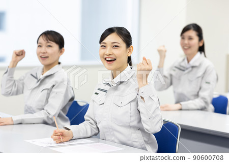 A woman in work clothes taking a seminar A woman in work clothes taking a seminar 90600708