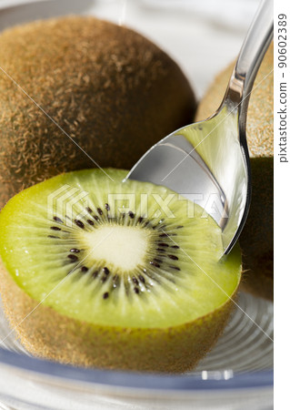 用勺子舀起切好的獼猴桃吃 90602389