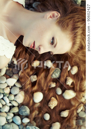 Beautiful young woman with unusual hairstyle on beach Beautiful young woman with unusual hairstyle on beach 90602427
