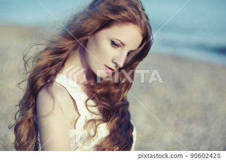 Beautiful woman with red hair at the sea 90602428