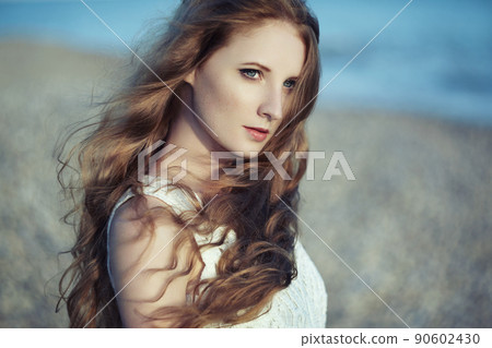 Beautiful woman with red hair at the sea Beautiful woman with red hair at the sea 90602430
