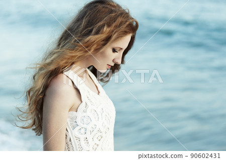Beautiful woman with red hair at the sea 90602431