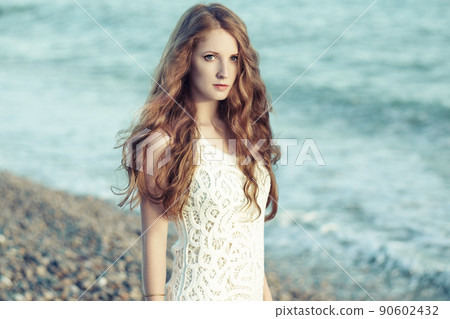 Beautiful woman with red hair at the sea Beautiful woman with red hair at the sea 90602432