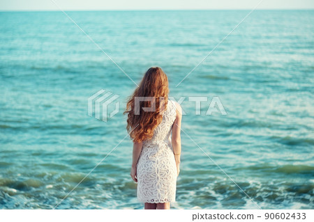 Beautiful woman with red hair at the sea Beautiful woman with red hair at the sea 90602433