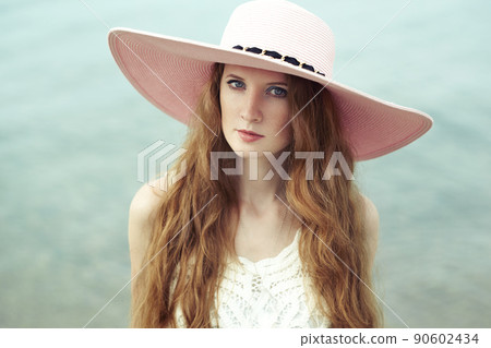 Beautiful woman in hat on the sea Beautiful woman in hat on the sea 90602434
